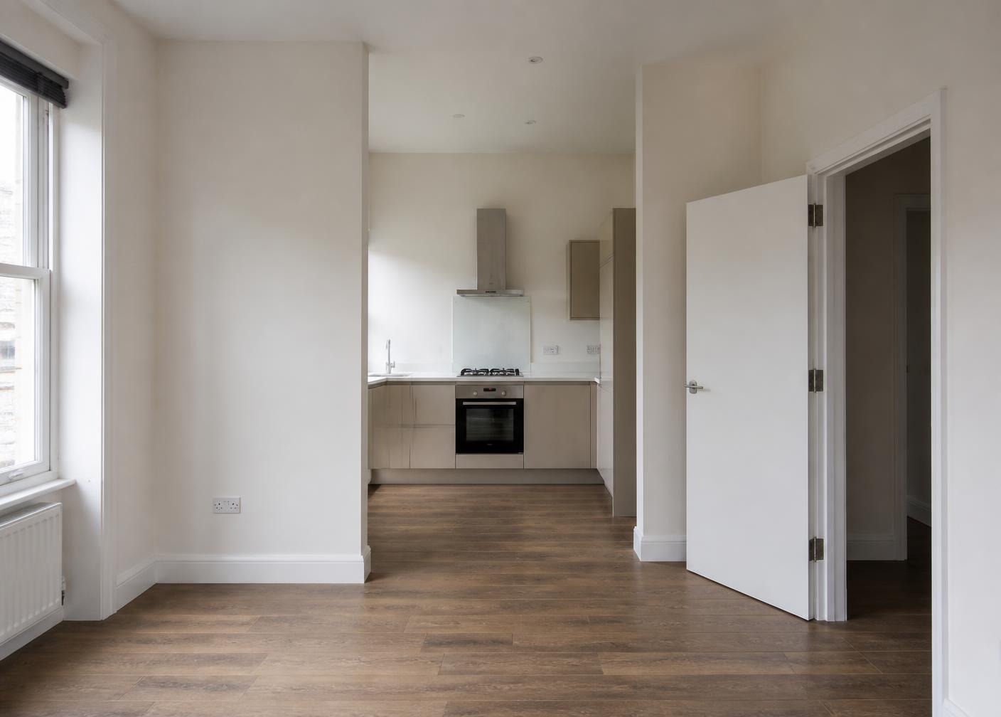 Clean, naturally lit British rental interior with neutral walls and wooden flooring